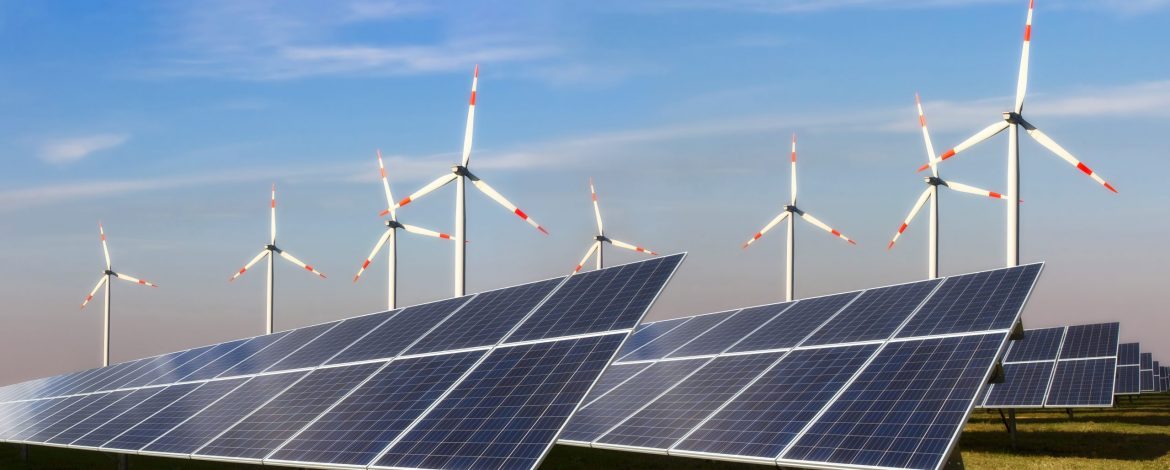 Photovoltaikanlage und Windkraftanlage vor blauem Himmel