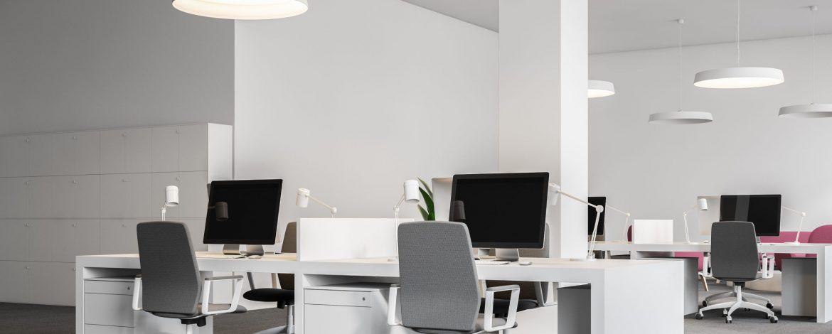 White office corner with gray carpet on the floor, white ceiling lamps and columns and rows of white computer desks. 3d rendering mock up