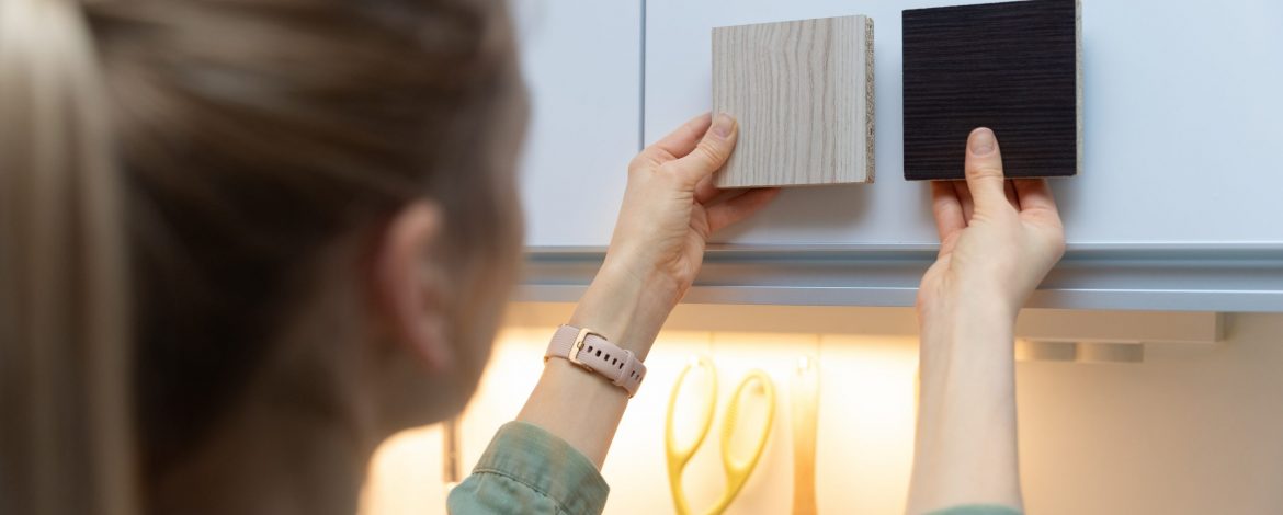 woman choosing kitchen cabinet materials from laminate samples